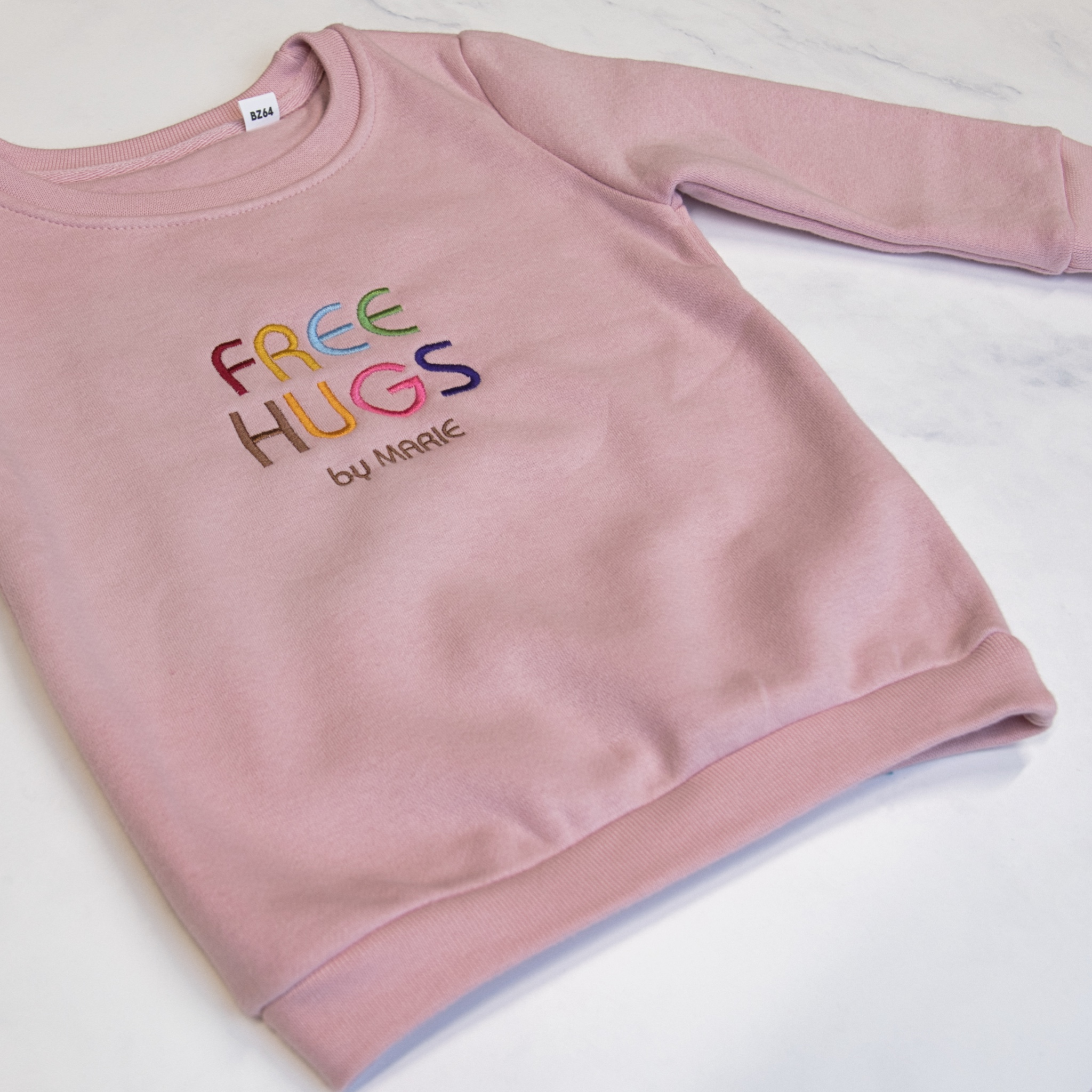 Voorbeeld van geborduurde Sweater "Free hugs by"